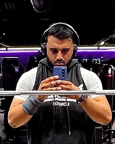 Omar, founder of OMR, taking a mirror photo in the gym